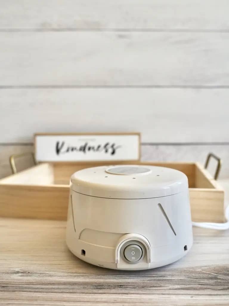 dohm white noise cancelling machine next to choose kindness sign on top of wooden tray