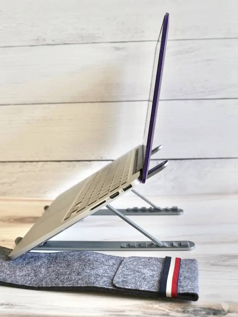 a macbook pro on top of a laptop stand for ergonomics