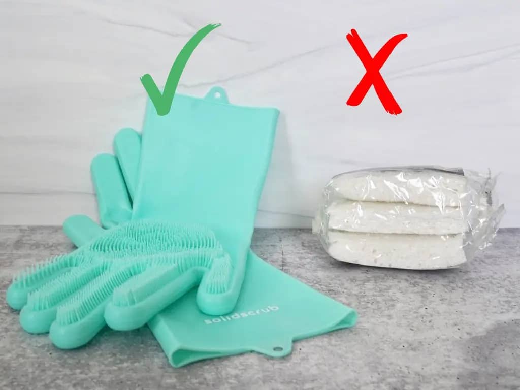 seafoam green silicone dish gloves next to white dish sponges